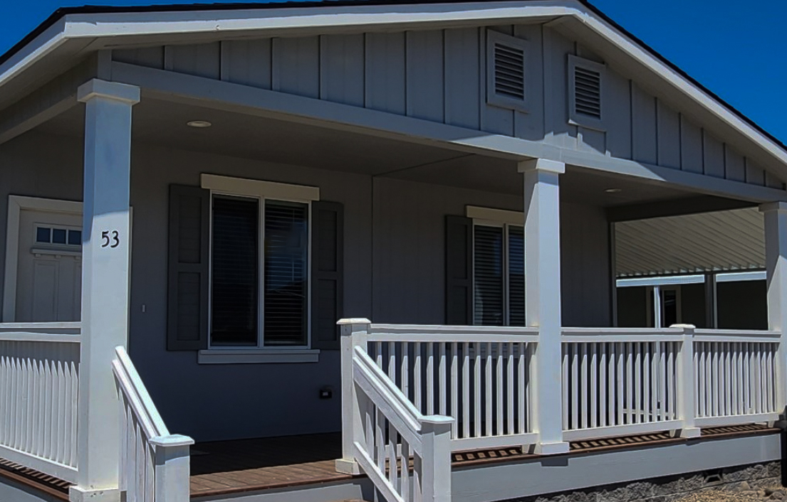 manufactured home with front porch, pitched roof, two front windows and front door